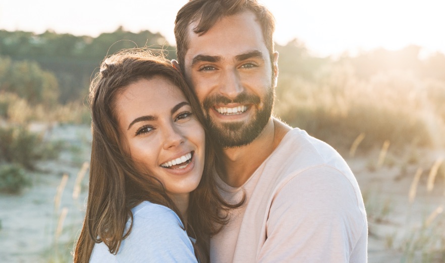 Beautiful young smiling couple spending time at the beach